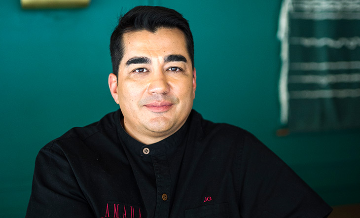 Photo of chef Jose Garces against a greenish blue wall